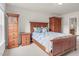 Bedroom features a wooden bed with blue and white bedding, a dresser, and neutral carpet at 106 Elmsford St, Durham, NC 27703