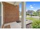 Brick exterior with white porch column, lush green bush, and landscaped bed at 106 Elmsford St, Durham, NC 27703