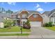 Traditional brick home featuring a well-maintained lawn, attached garage, and covered front entry at 106 Elmsford St, Durham, NC 27703