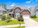 Charming brick two-story home with a well-manicured lawn, mature trees, and a two-car garage at 106 Elmsford St, Durham, NC 27703