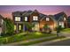 Elegant two-story red brick home with a well-manicured lawn and a two-car garage at twilight at 106 Elmsford St, Durham, NC 27703