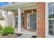 Inviting front porch of a brick home with white columns and a gray front door at 106 Elmsford St, Durham, NC 27703