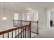 Upstairs hallway with wood and iron railing, neutral walls, and open doorways, creating an airy and inviting transition space at 106 Elmsford St, Durham, NC 27703
