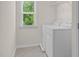 Bright laundry room featuring tile floors, washer and dryer, and a large window with natural light at 106 Elmsford St, Durham, NC 27703