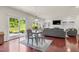 Open-concept living room with fireplace, built-ins, dining table, light gray furnishings, and backyard access at 106 Elmsford St, Durham, NC 27703