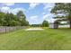 Spacious backyard featuring a basketball court, storage shed, wooden fence and mature trees at 109 D A King Dr, Willow Springs, NC 27592
