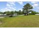 Expansive backyard featuring a covered carport, storage sheds, mature trees, and plenty of green space at 109 D A King Dr, Willow Springs, NC 27592