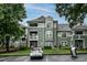Inviting condo with multiple balconies, large windows and green siding, surrounded by mature trees and lush landscaping at 1111 Parkridge Ln # 103, Raleigh, NC 27605