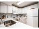 Well-lit kitchen featuring white cabinets, appliances and a stainless sink at 1111 Parkridge Ln # 103, Raleigh, NC 27605