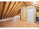Unfinished attic space with exposed rafters, insulation, and a door at 113 Cedardale Ct, Clayton, NC 27520