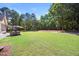 Expansive backyard with patio seating, mature trees and lush green lawn at 113 Cedardale Ct, Clayton, NC 27520
