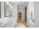 Well-lit bathroom featuring double sinks, white cabinets, walk in shower, and a separate soaking tub at 113 Cedardale Ct, Clayton, NC 27520