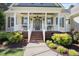 Inviting front porch with classic columns, brick steps, and lush landscaping, a warm welcome at 113 Cedardale Ct, Clayton, NC 27520