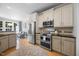 Well-lit kitchen featuring stainless steel appliances, hardwood floors, and seamless access to a bright sitting room at 113 Cedardale Ct, Clayton, NC 27520