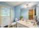 Bright bathroom with a single sink vanity, toilet, and window at 115 Redbay Ln, Clayton, NC 27527