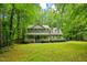 Charming two-story home featuring a welcoming front porch and lush landscaping surrounded by mature trees at 115 Redbay Ln, Clayton, NC 27527