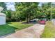 Large backyard featuring lush green grass, mature trees, and ample parking space at 118 Lynn Rd, Durham, NC 27703