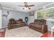 Spacious living room with plush seating, ceiling fan, and natural light from a large window at 118 Lynn Rd, Durham, NC 27703