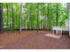 Wooded backyard with wooden deck and brick patio at 1208 Mossy Glade Cir, Apex, NC 27502