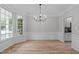 Spacious dining room with hardwood floors, large windows, decorative molding, and a modern light fixture at 1208 Mossy Glade Cir, Apex, NC 27502