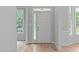 Bright entryway featuring a white front door with sidelight windows and hardwood flooring at 1208 Mossy Glade Cir, Apex, NC 27502
