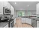 Open kitchen with stainless appliances, and wood flooring at 1208 Mossy Glade Cir, Apex, NC 27502