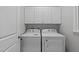 Bright laundry room featuring a washer, dryer, and overhead cabinets for convenient storage at 1208 Mossy Glade Cir, Apex, NC 27502