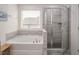 Luxurious bathroom with soaker tub, glass shower, and tiled walls at 1213 Grenshaw Dr, Morrisville, NC 27560