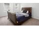 Bright bedroom features a dark wood bed frame, neutral carpet, and windows at 1213 Grenshaw Dr, Morrisville, NC 27560