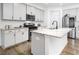Modern kitchen featuring white cabinets, an island with marble countertops, and stainless steel appliances at 1213 Grenshaw Dr, Morrisville, NC 27560