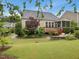 A picturesque backyard showcases a wooden deck, stone patio, and well-manicured lawn at 136 Shadow Hawk Dr, Durham, NC 27713