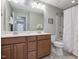 Well-lit bathroom featuring double sinks, wood cabinets, shower with tub and neutral tile flooring at 136 Shadow Hawk Dr, Durham, NC 27713