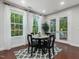 Bright dining area with large windows, stylish rug, and access to the outdoor porch at 136 Shadow Hawk Dr, Durham, NC 27713