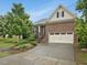 Attractive brick home with an attached garage, landscaped front yard, and inviting curb appeal at 136 Shadow Hawk Dr, Durham, NC 27713