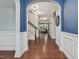 Hallway with hardwood floors, archway, and white wainscotting at 136 Shadow Hawk Dr, Durham, NC 27713