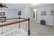 Upstairs hallway with carpet and wooden railing leading to other rooms in the home at 136 Shadow Hawk Dr, Durham, NC 27713