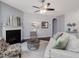 Bright living room with a cozy fireplace, neutral color palette and multiple windows dressed with white sheer curtains at 136 Shadow Hawk Dr, Durham, NC 27713