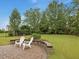 Inviting patio seating area with a lush lawn and manicured landscaping at 136 Shadow Hawk Dr, Durham, NC 27713