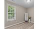Bright bedroom features a large window, neutral colored walls, wood-look flooring, and decorative accents at 139 Carriage Hill Dr, Stem, NC 27581