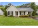 Charming single-story home with manicured lawn, black shutters, and inviting front porch seating at 139 Carriage Hill Dr, Stem, NC 27581