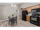 Open-concept kitchen features black appliances, wood cabinets, wood-look flooring, and neutral colored walls at 139 Carriage Hill Dr, Stem, NC 27581