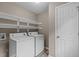 Laundry room features a washer, dryer, white shelving, neutral colored walls, and wood-look flooring at 139 Carriage Hill Dr, Stem, NC 27581