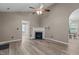Open living area featuring a cozy fireplace, neutral paint, and modern ceiling fan at 139 Carriage Hill Dr, Stem, NC 27581