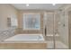 Bright bathroom with a luxurious soaking tub and a glass-enclosed shower with tile accents at 1920 Bright Kannon Way, Wendell, NC 27591
