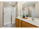 Bathroom featuring double sinks, white countertops, framed mirror, and shower with glass door at 1984 Sadler Ave, Creedmoor, NC 27522