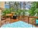 Well kept wood deck featuring an outdoor grill, seating, and backing to a playground at 1984 Sadler Ave, Creedmoor, NC 27522