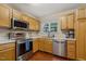 Efficient kitchen featuring stainless steel appliances, wood cabinets, and plenty of natural light at 1984 Sadler Ave, Creedmoor, NC 27522