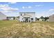 The backyard shows the two-story home and the covered patio with furniture at 200 Gill Farm Way, Franklinton, NC 27525