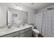 Well-lit bathroom featuring double sinks, and a shower with patterned curtain at 200 Gill Farm Way, Franklinton, NC 27525