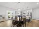 Eat-in kitchen with a view of the backyard and modern lighting fixtures over dark-stained wood dining table at 200 Gill Farm Way, Franklinton, NC 27525